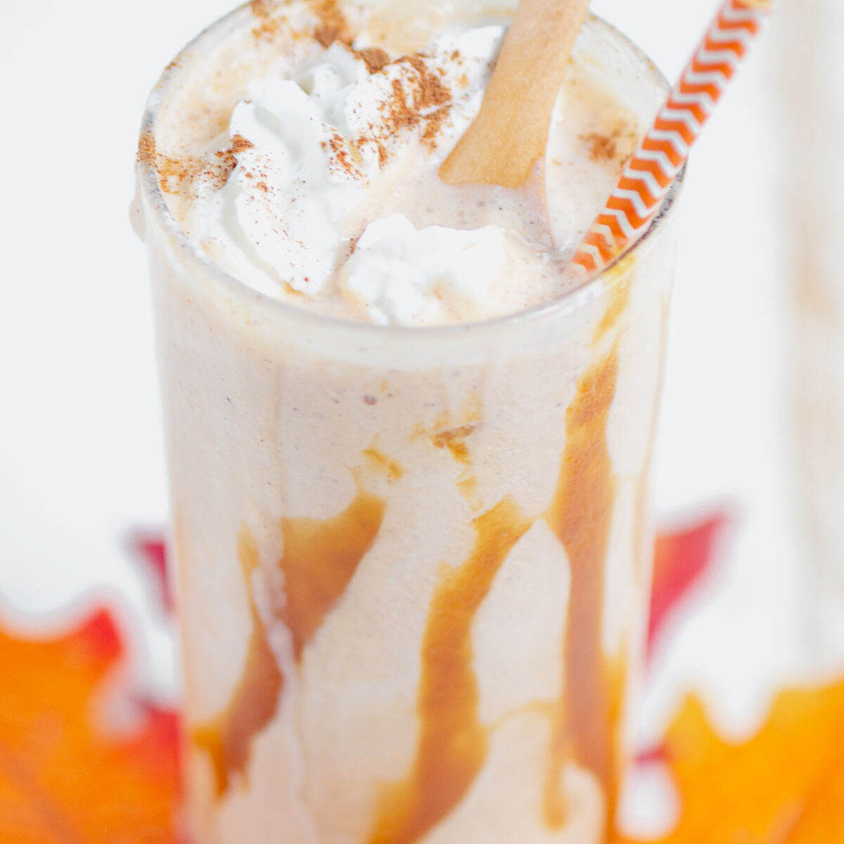 pumpkin shake in a clear glass with a wooden spoon