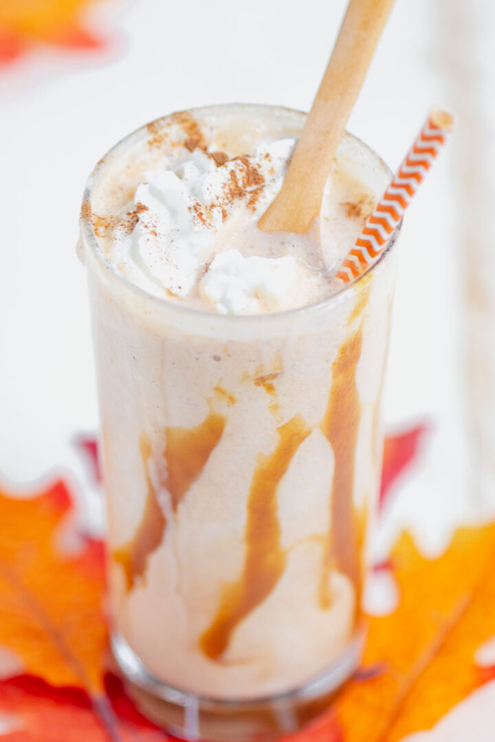 pumpkin shake in a clear glass with a wooden spoon