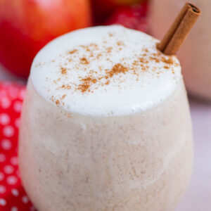 smoothie in a short glass with whipped cream and a cinnamon stick