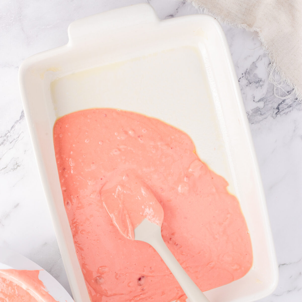strawberry cake batter in a white pan