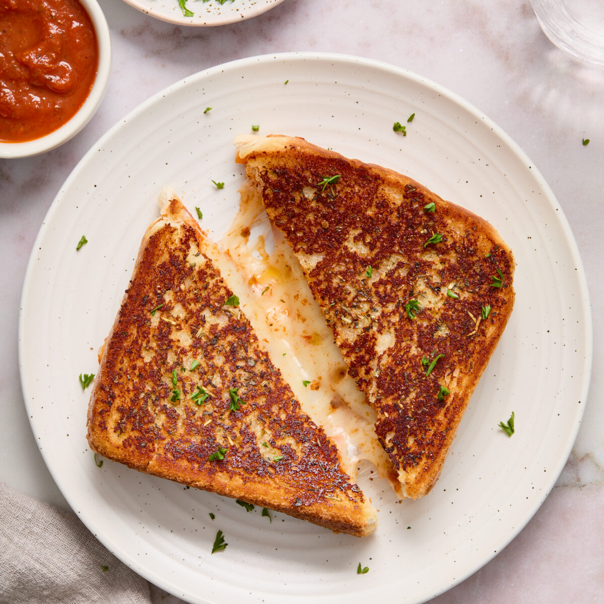 grilled cheese cut in half on a white plate