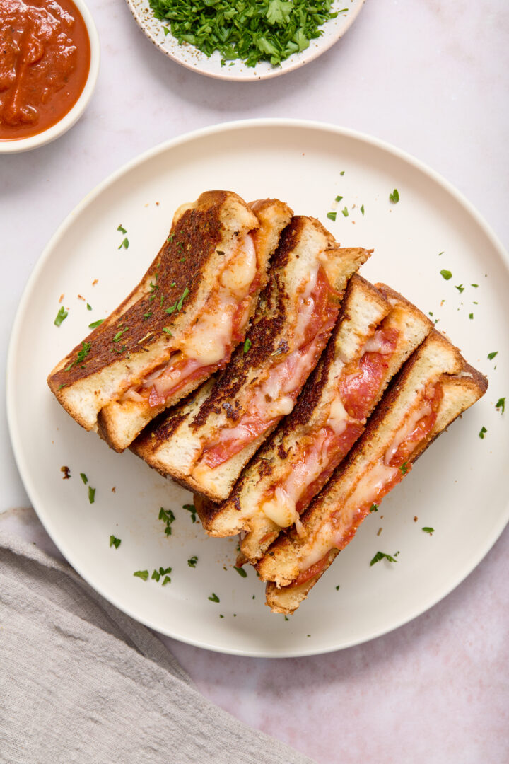 grilled cheese cut in half on a white plate