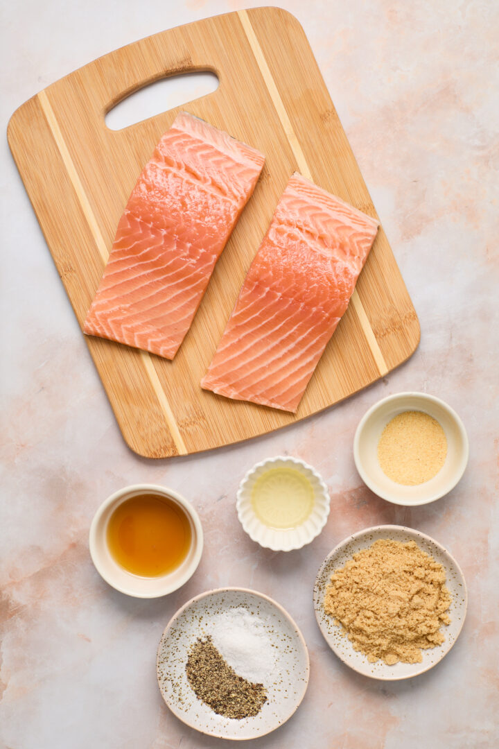 ingredient on a brown cutting board and light pink surface