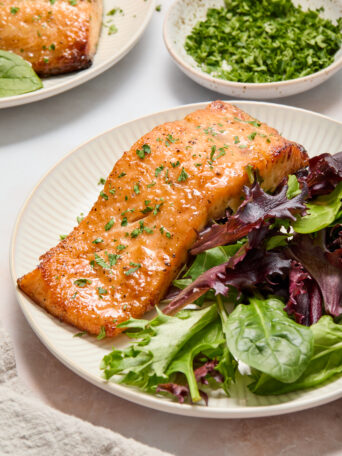 salmon and green lettuce on a white plate