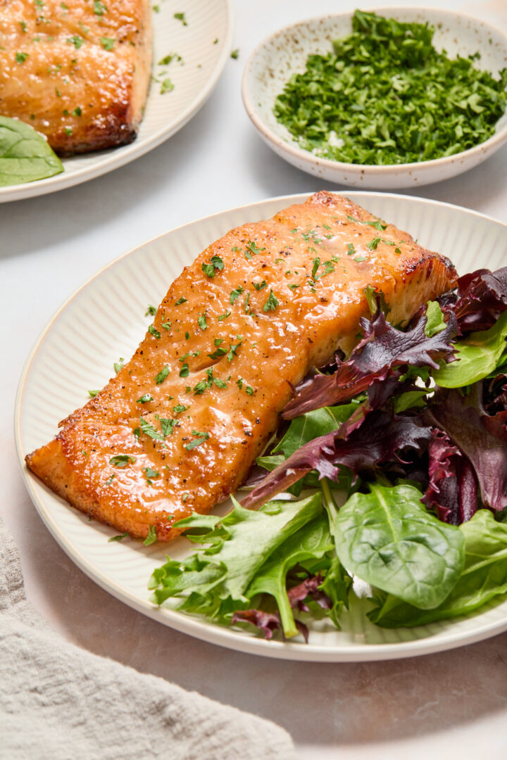 salmon and green lettuce on a white plate