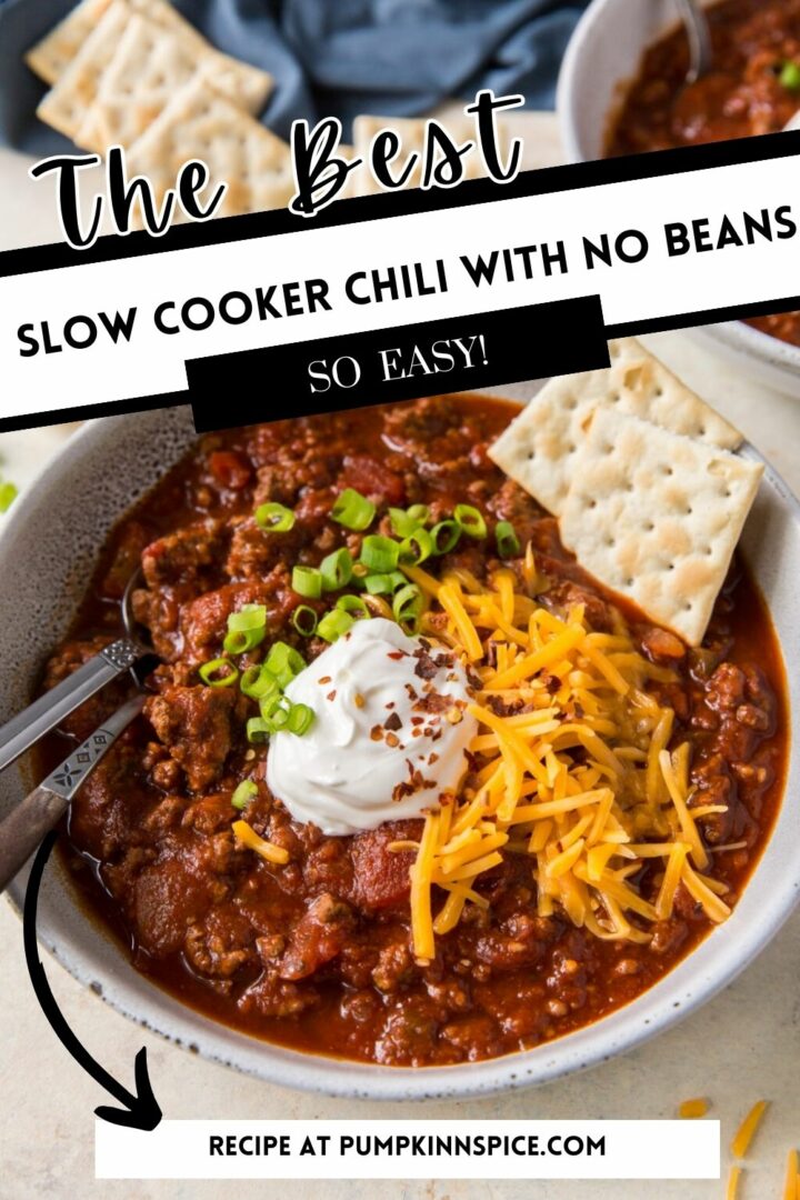 chili in a white bowl with cheese, sour cream, and crackers