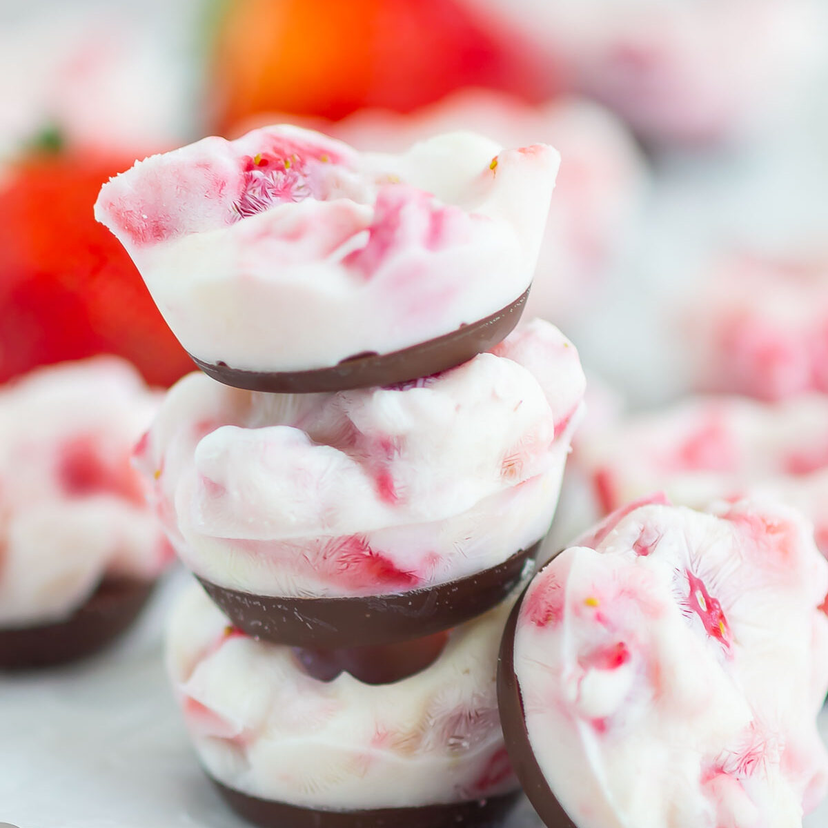 yogurt bites stacked on top of each other on white parchment paper