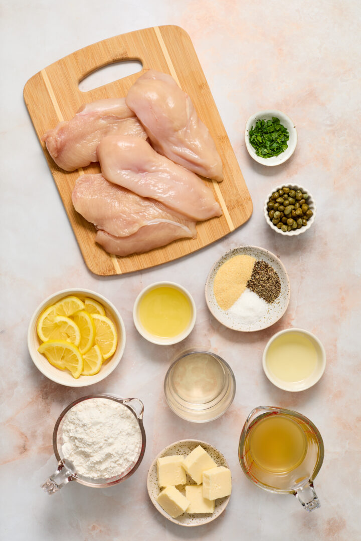 chicken piccata ingredients shown on a light pink surface