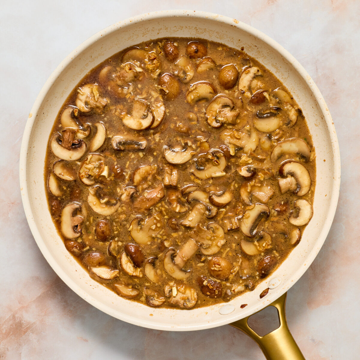 mushroom gravy simmering in a white pan
