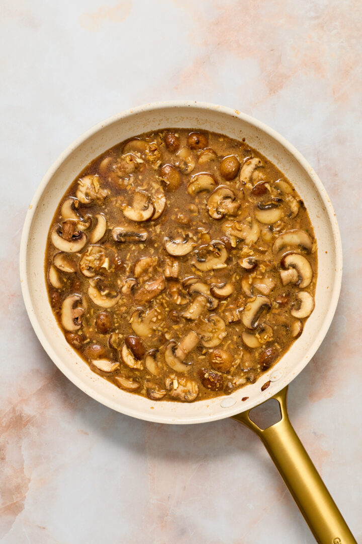 mushroom gravy simmering in a white pan