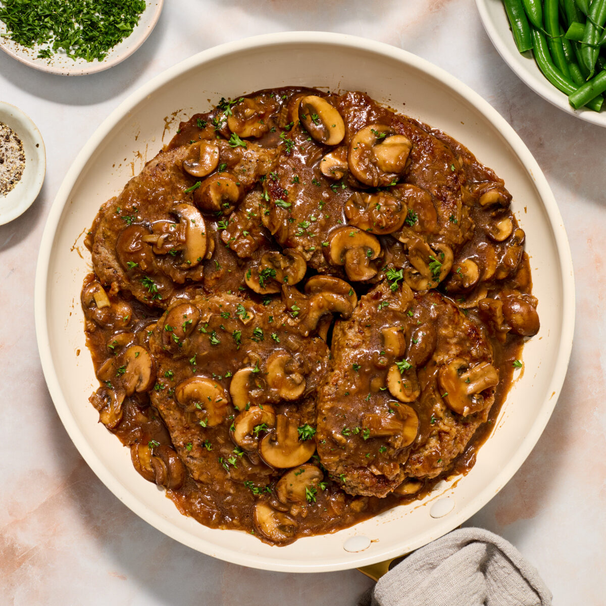 cube steak and mushroom gravy in a white pan