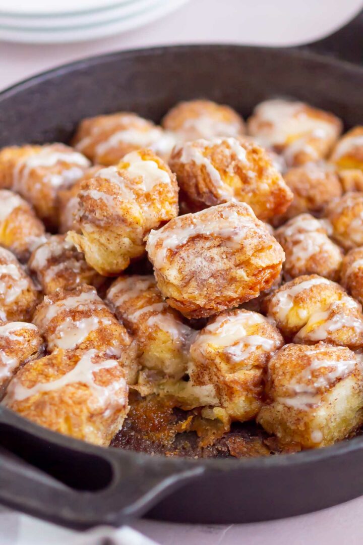 monkey bread in a cast iron skillet with pieces taken out