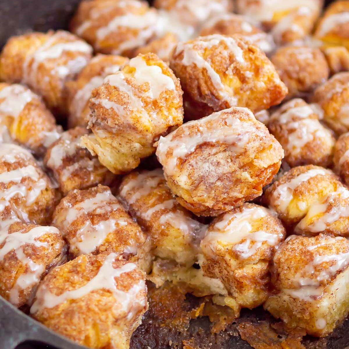 monkey bread with pieces taken out in a cast iron skillet