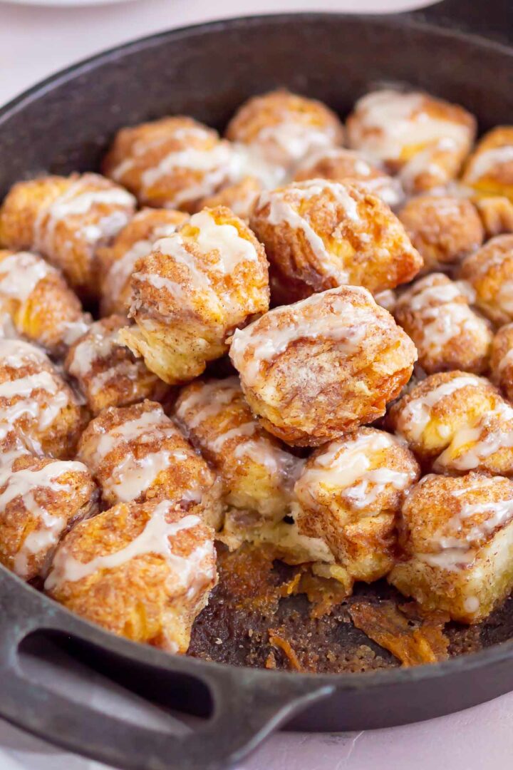 monkey bread with pieces taken out in a cast iron skillet