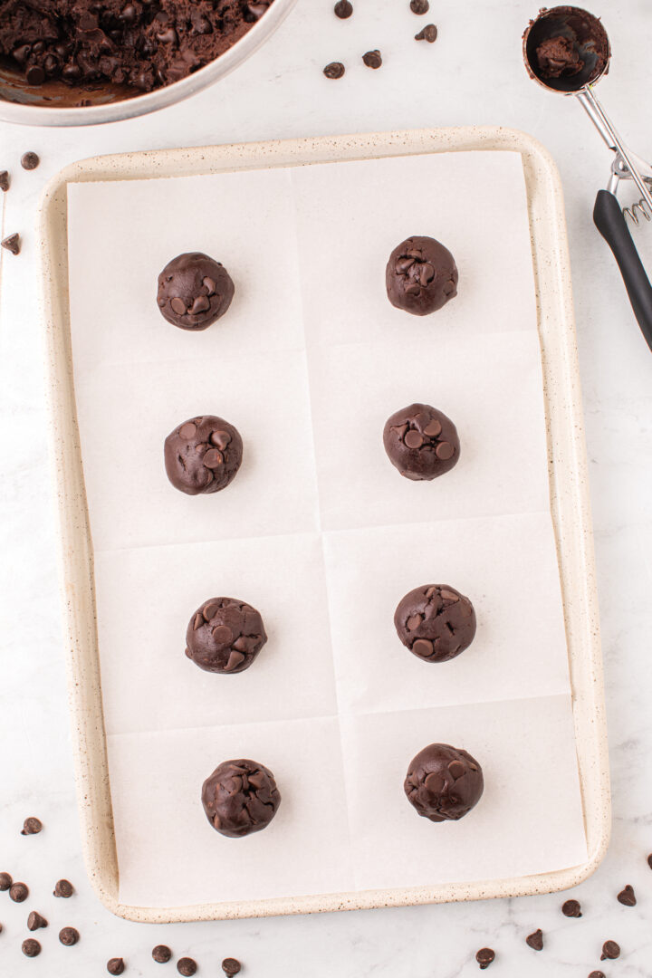 cookie batter scooped onto a parchment paper-lined pan 