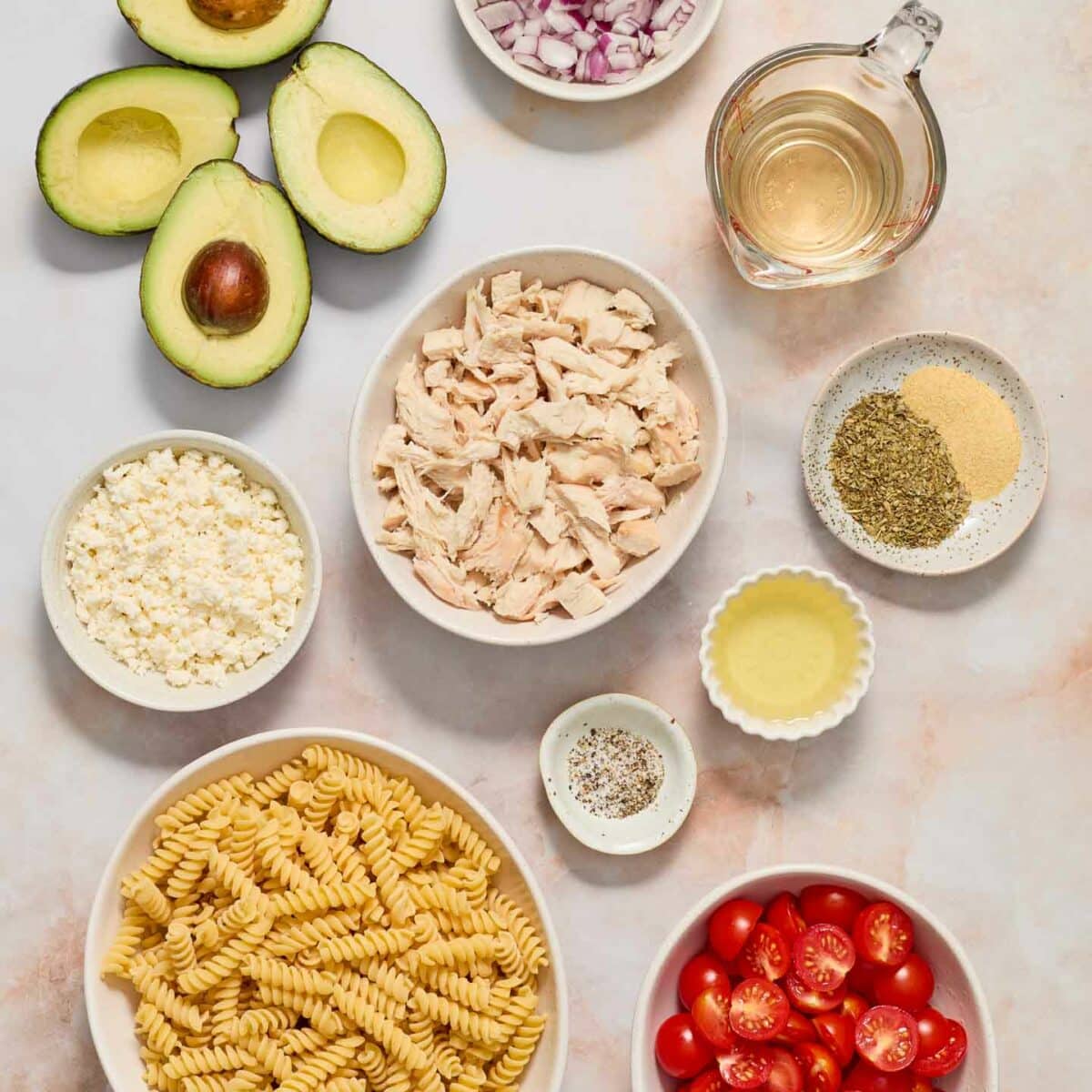 pasta salad ingredients in white bowls
