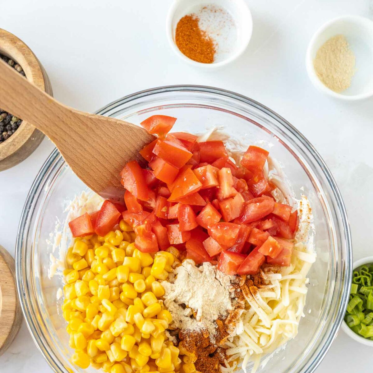 corn dip ingredients being mixed in a glass bowl