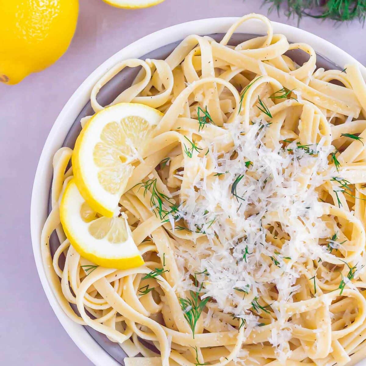 pasta in a white bowl with parmesan cheese on top