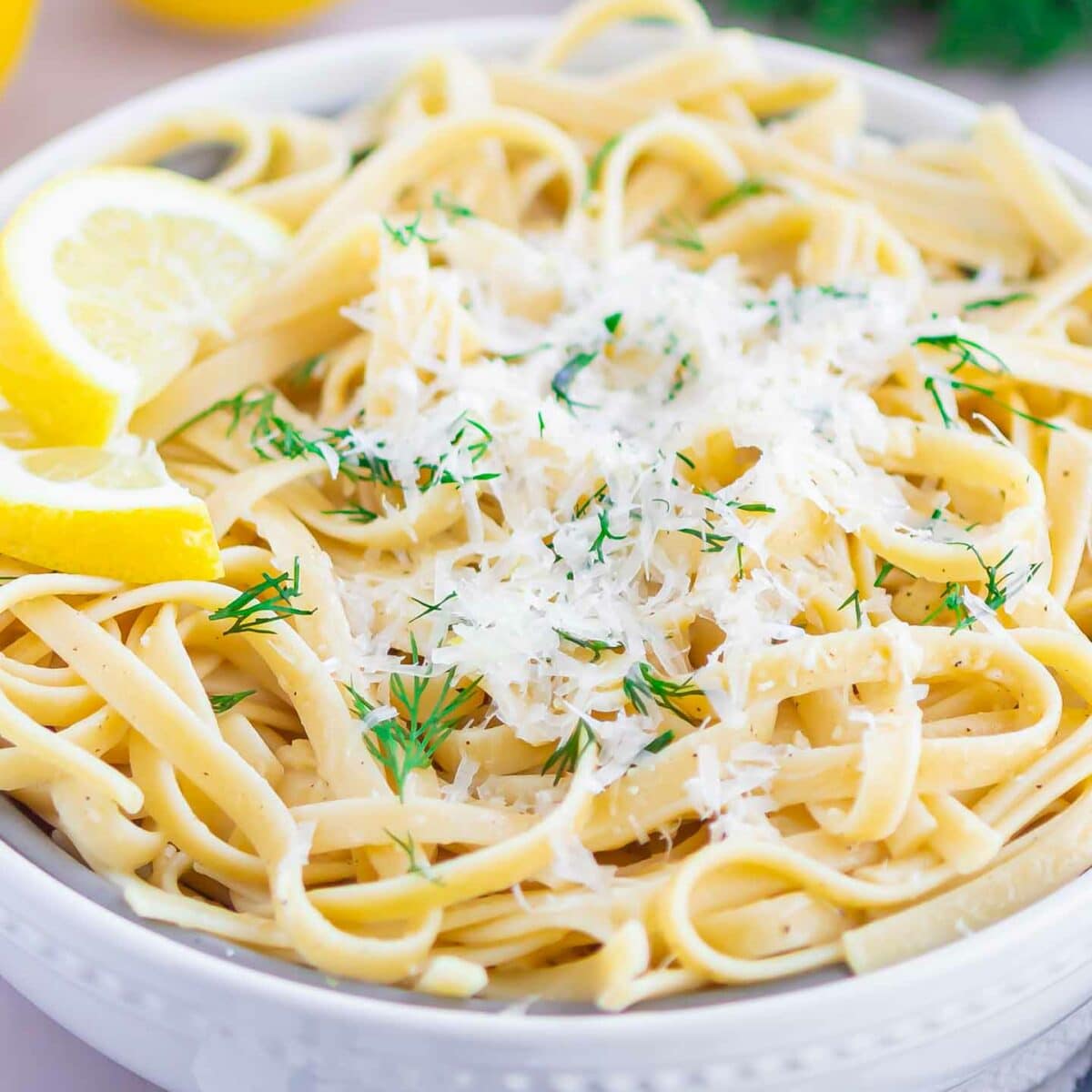 pasta in a white bowl with cheese on top