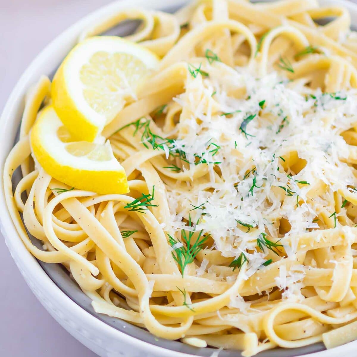 pasta in a white bowl with parmesan cheese on top