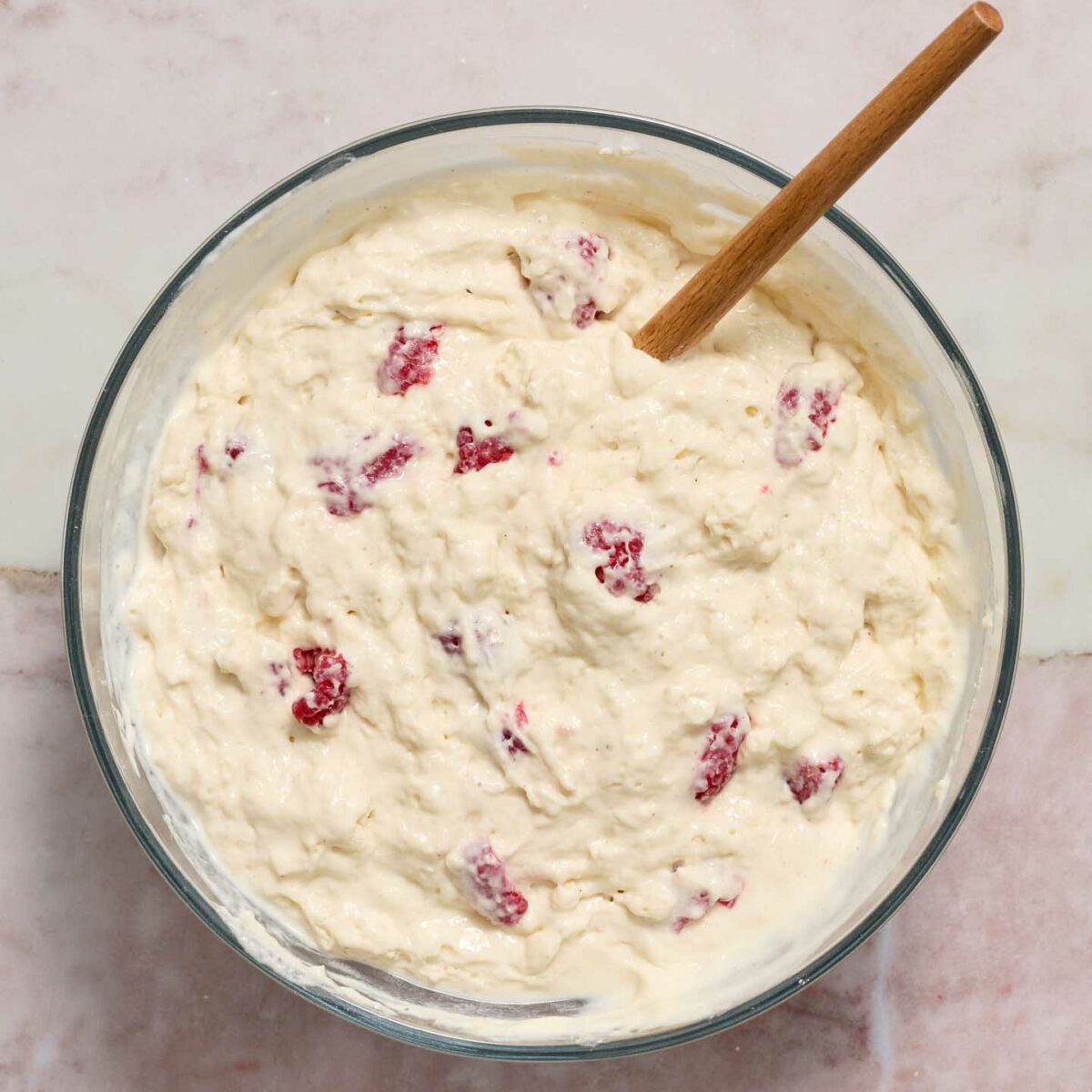 pancake ingredients being mixed in a bowl with a wooden spoon