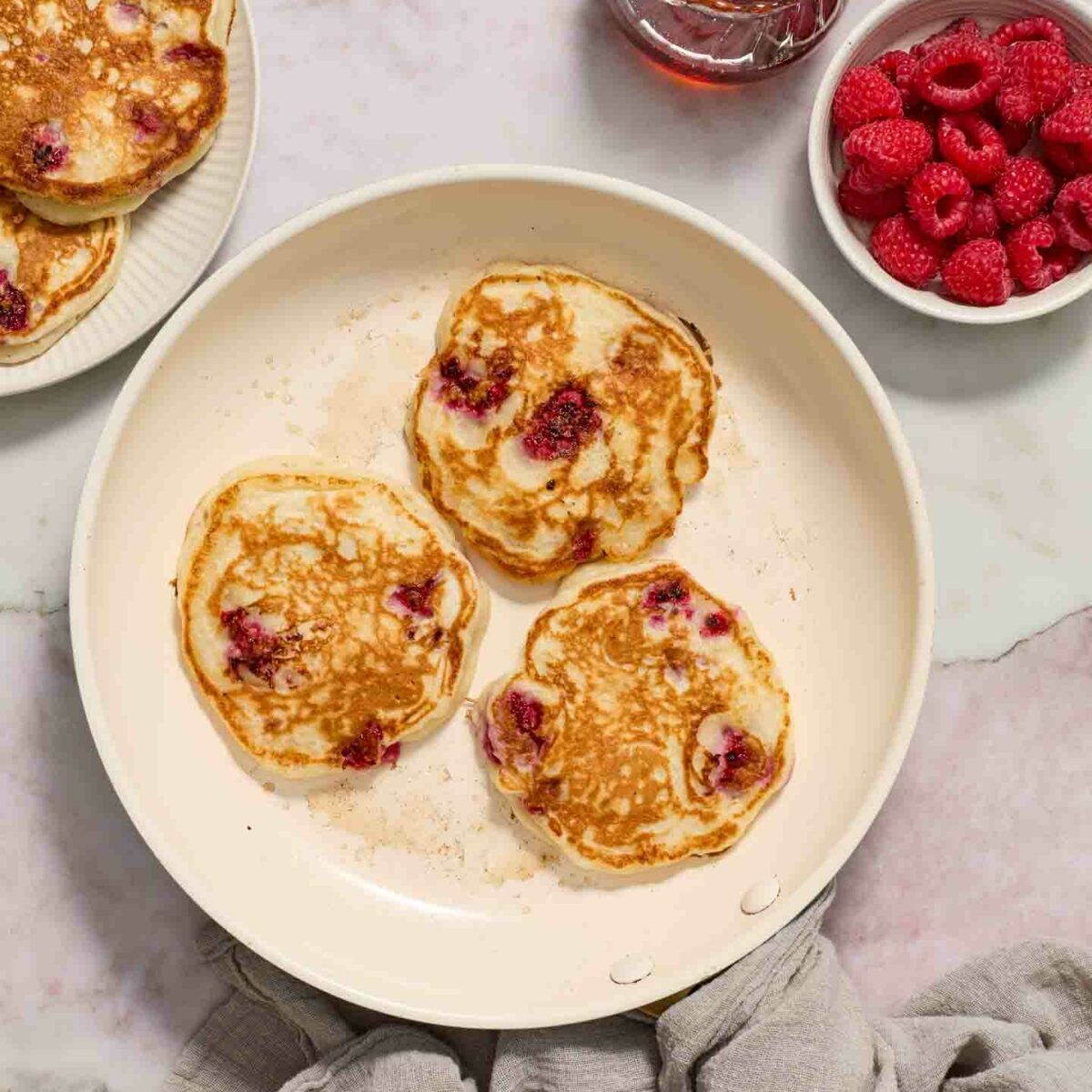 pancakes cooked and browned in a white skillet