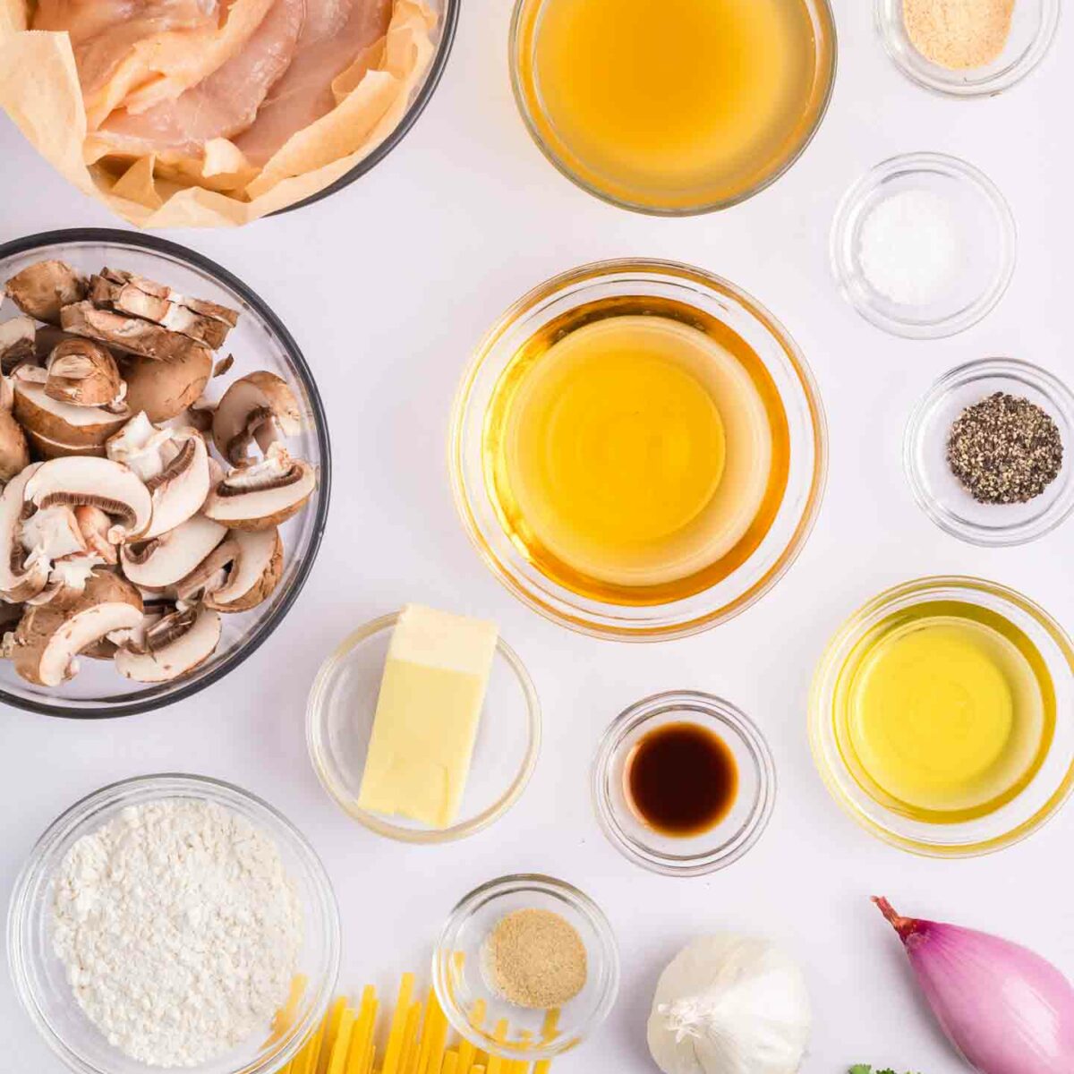 chicken marsala pasta ingredients in glass bowls on a white surface