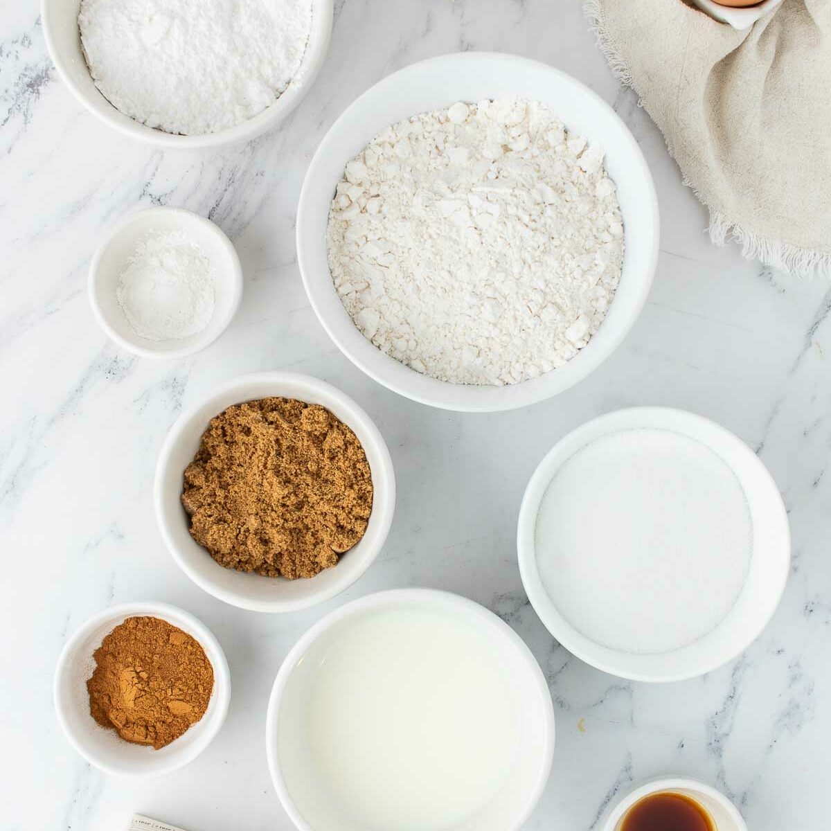 ingredients in white bowls on a white surface
