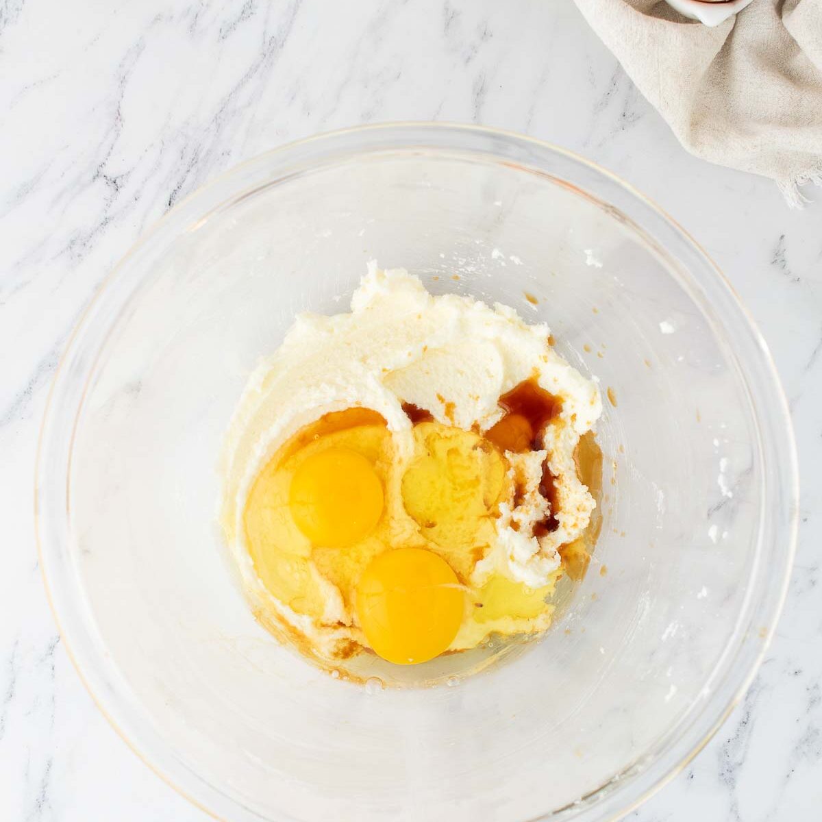 eggs and vanilla added to butter and sugar mixture in a glass bowl