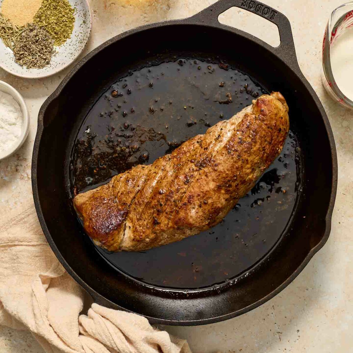 pork seasoned and seared in a black skillet