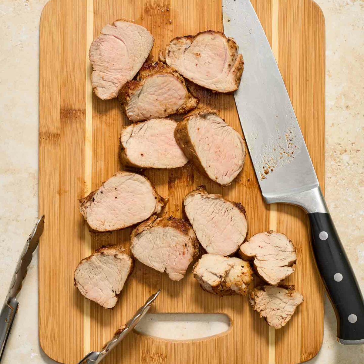pork  tenderloin sliced on a wooden cutting board