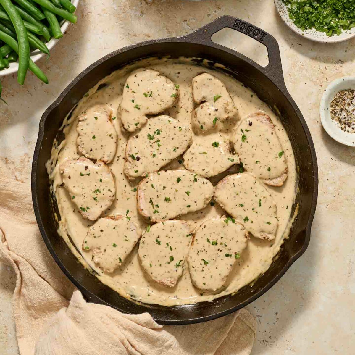 sliced pork tenderloin in cream sauce in a black skillet