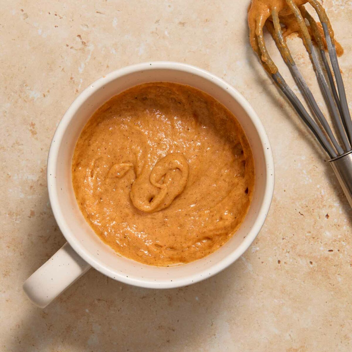 wet ingredients mixed in with dry ingredients in a white mug