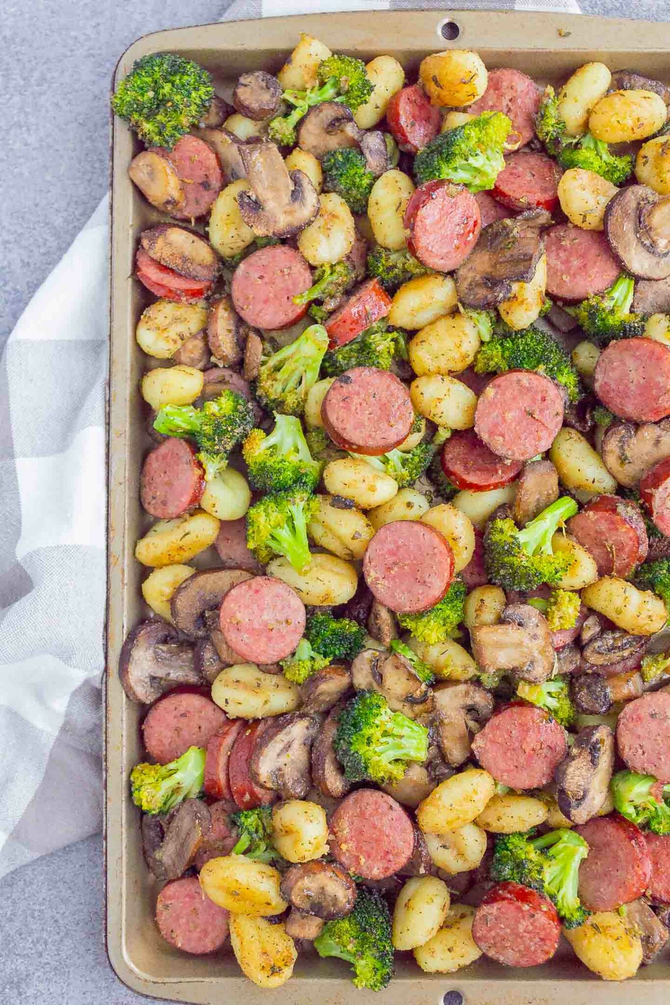 Sausage, gnocchi, broccoli and mushrooms on a sheet pan.