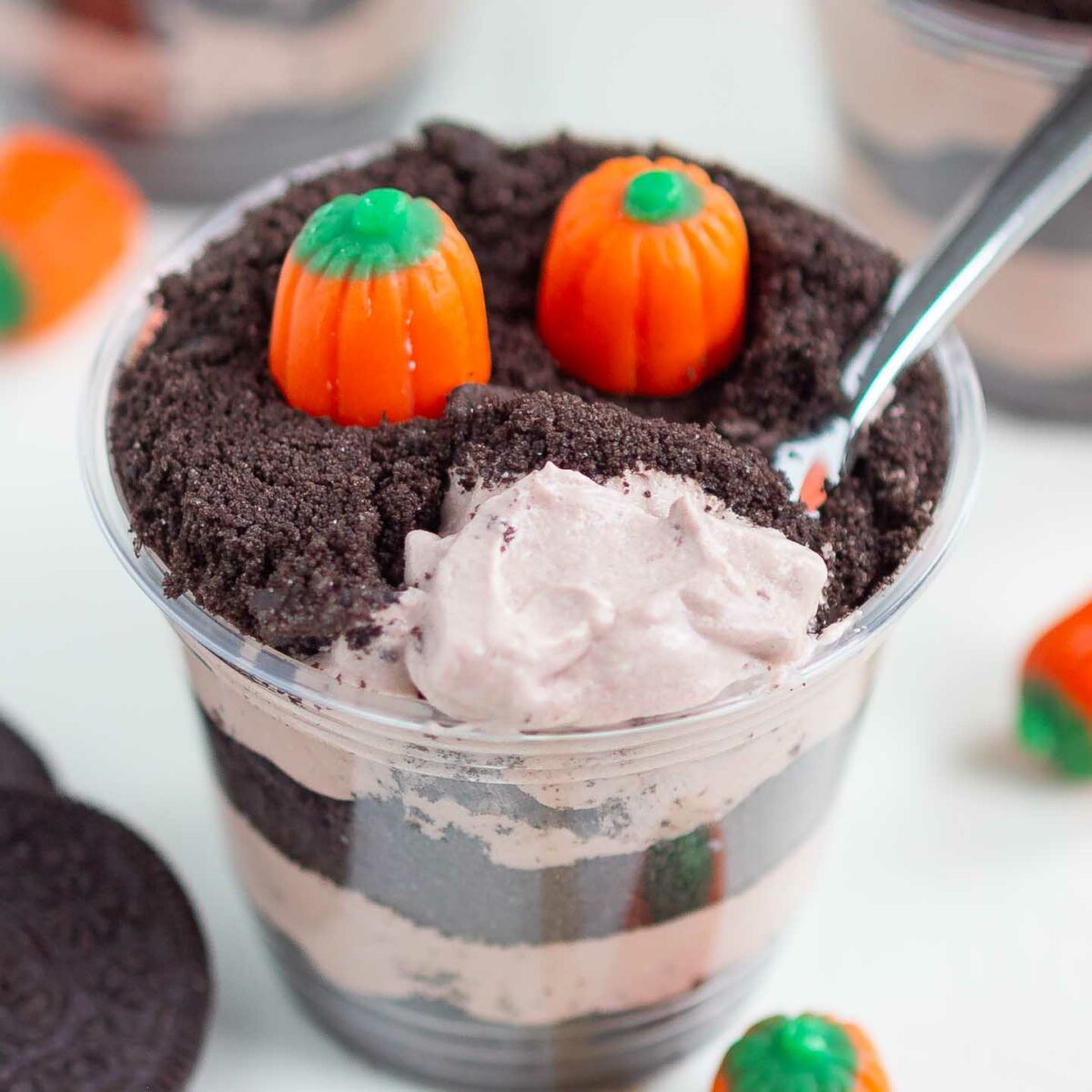 dirt cup on a white surface with a spoonful of pudding shown