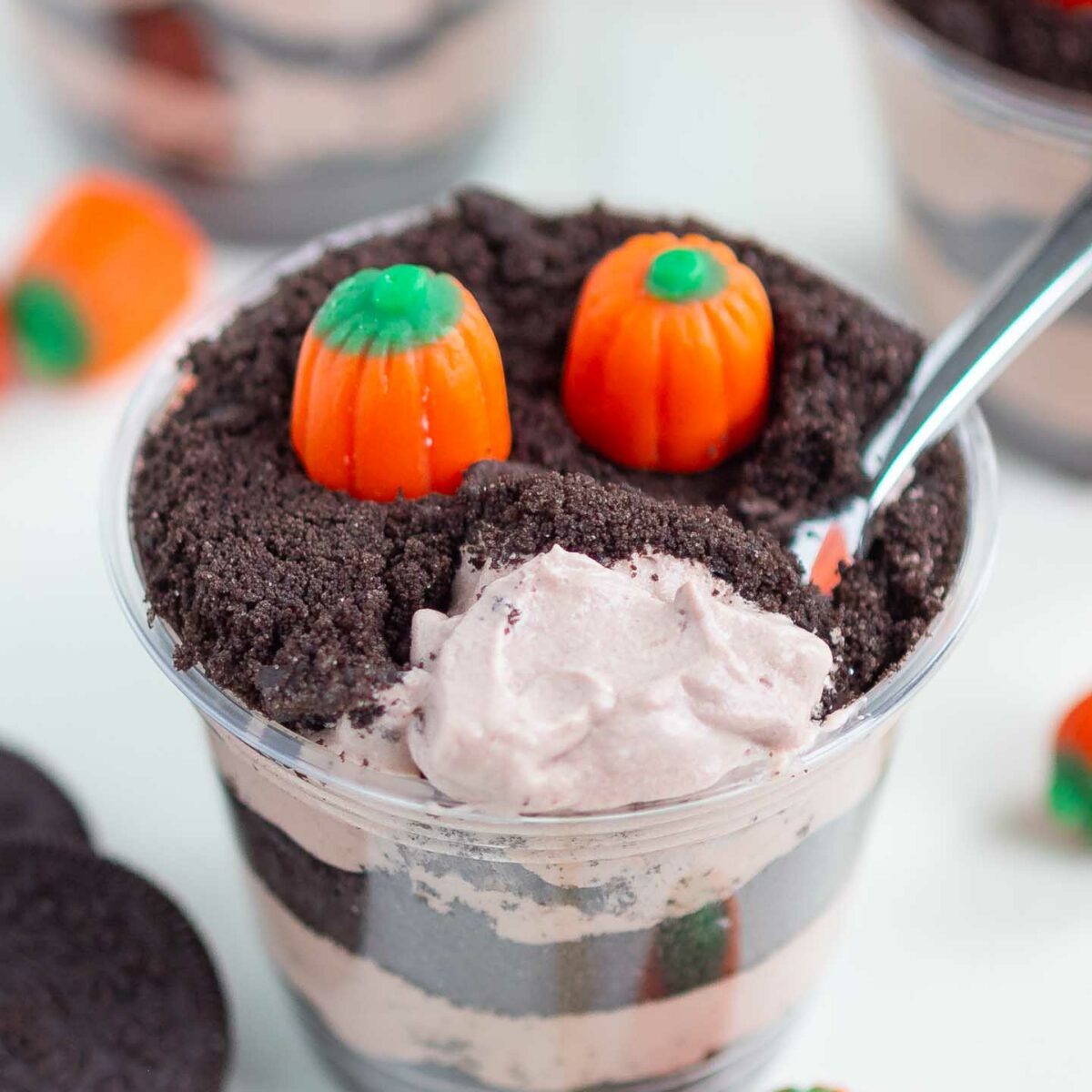 dirt cup on a white surface with a spoonful of pudding shown