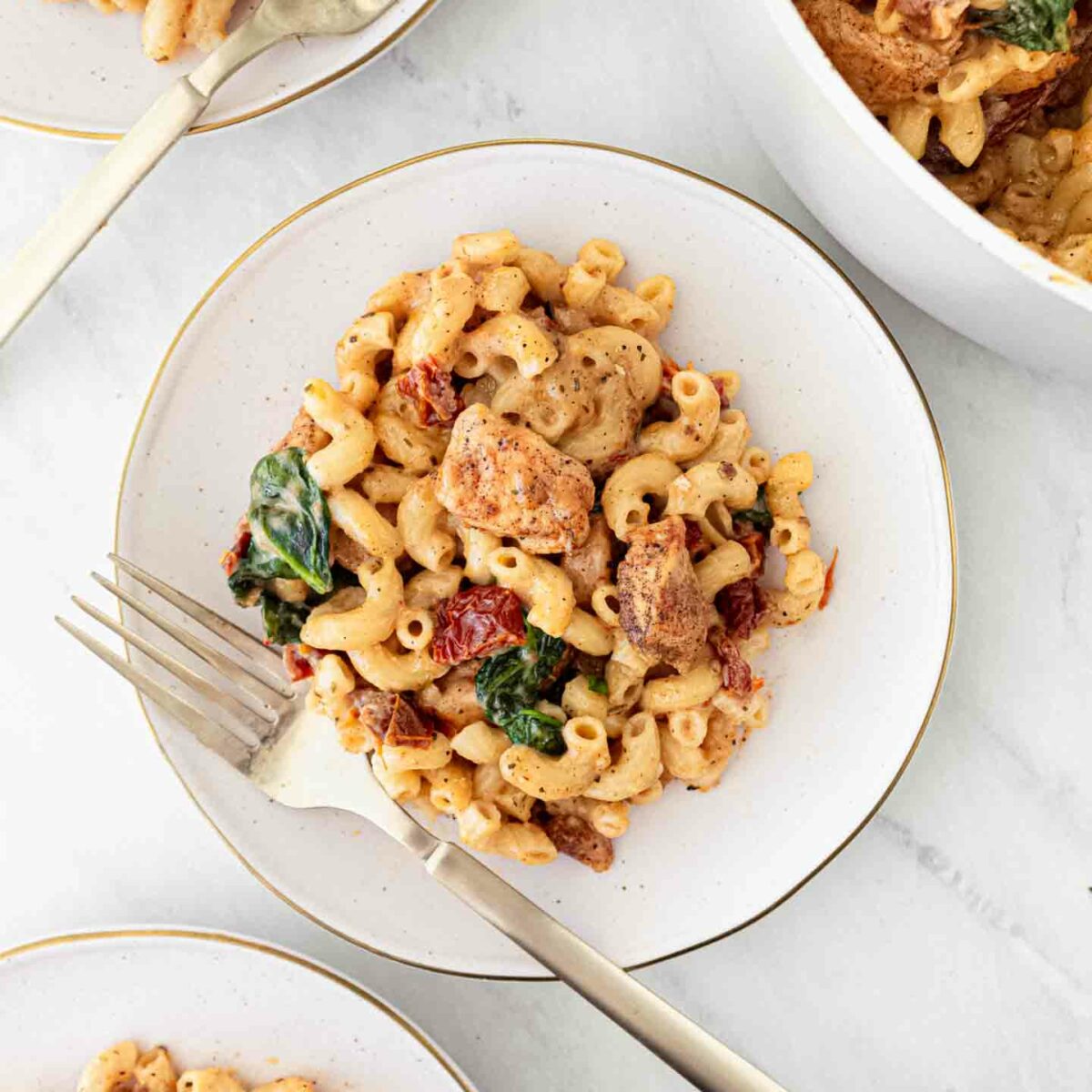 chicken mac and cheese on a white plate with a fork