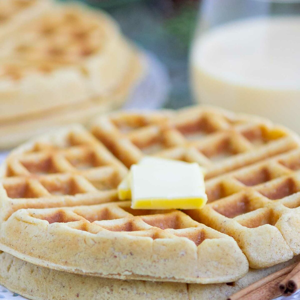 eggnog waffles with butter on a white plate