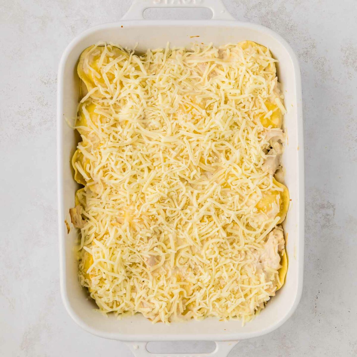 ravioli with chicken and alfredo topped with shredded cheese