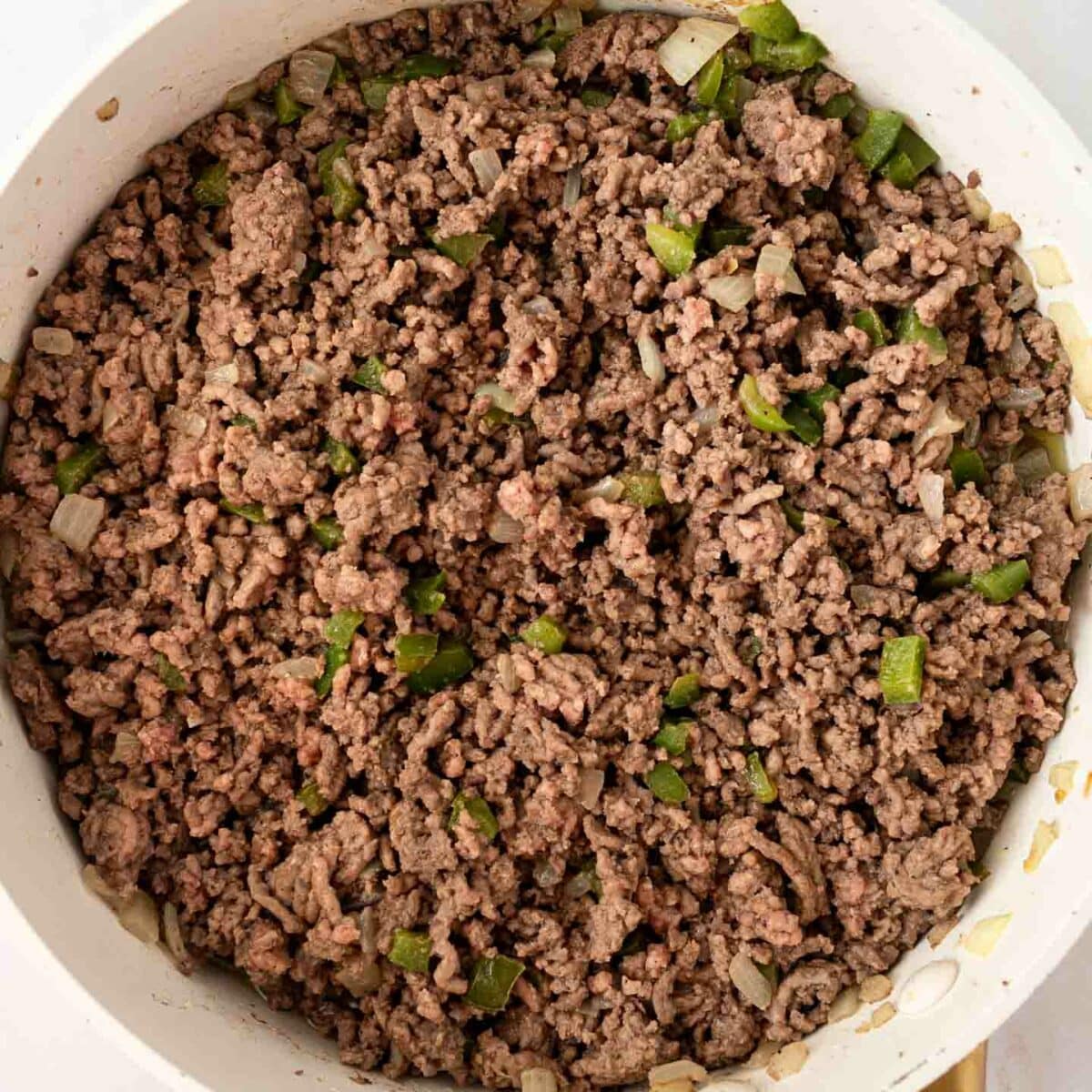 ground beef mixture cooked in a white skillet