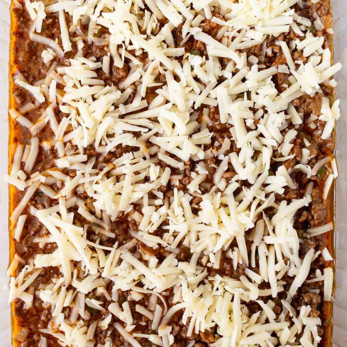 casserole in a dish with shredded cheese on top