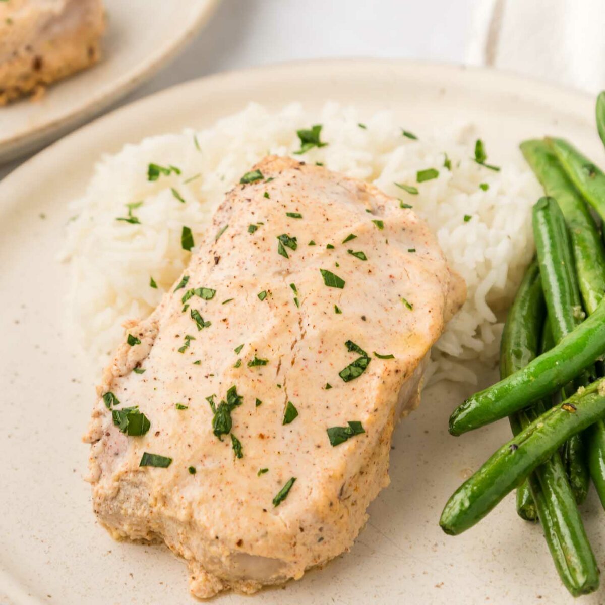 pork chops plated with mashed potatoes and green beans