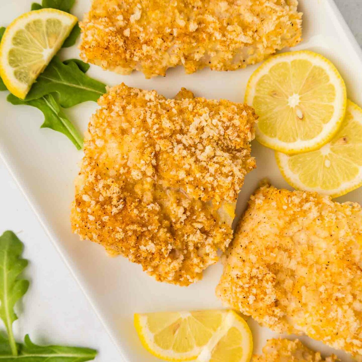 cod show on a white plate with lemon slices