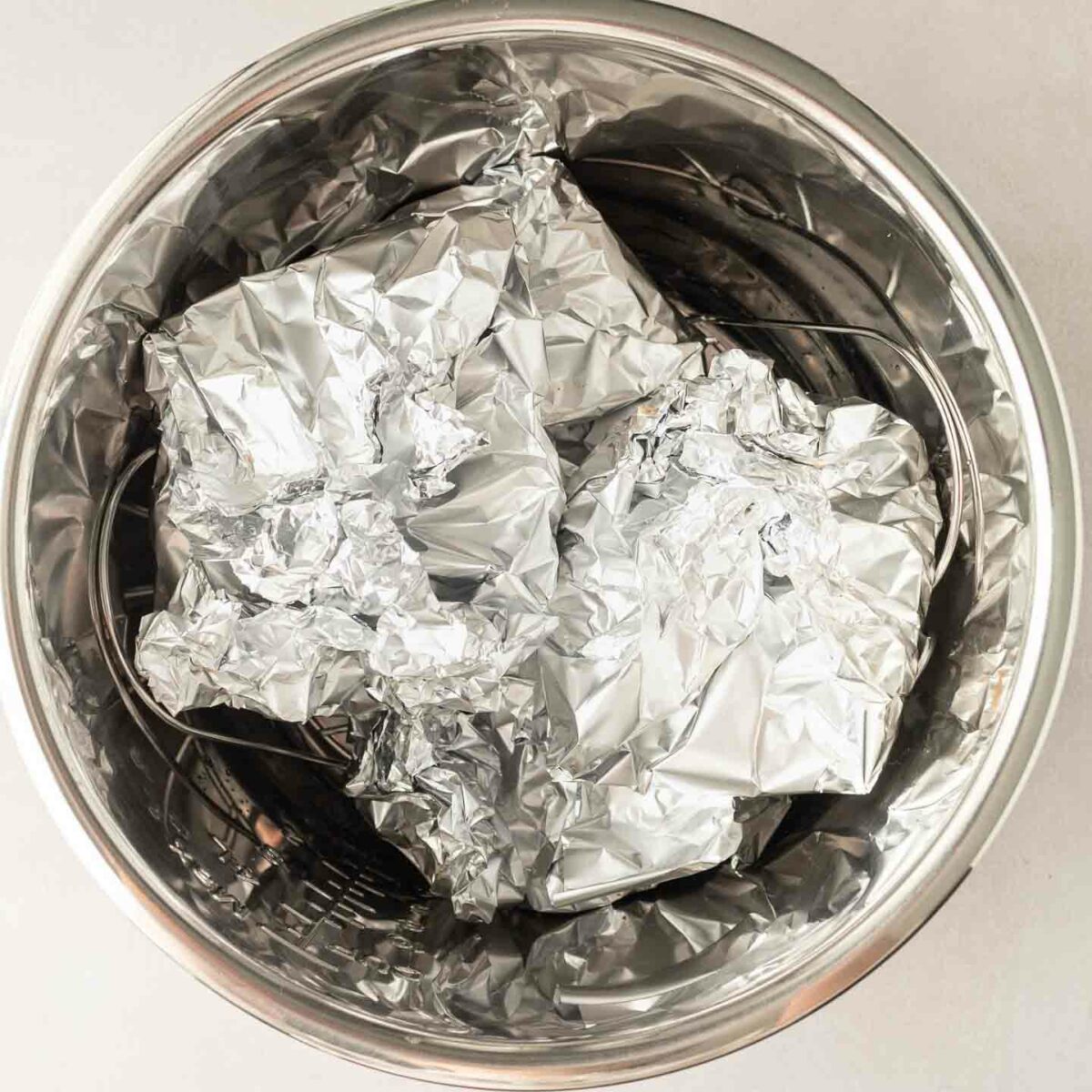 burgers wrapped in foil and placed in the pressure cooker