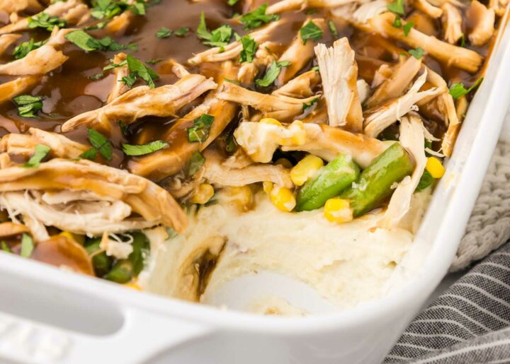 casserole in a white dish with a piece removed to show the filling