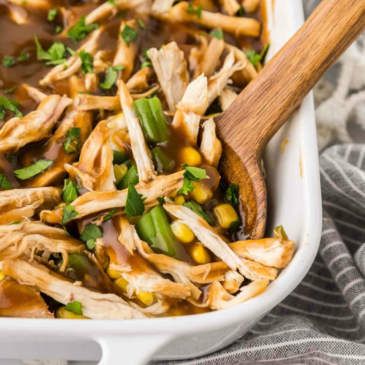 casserole in a white dish with a wooden spoon