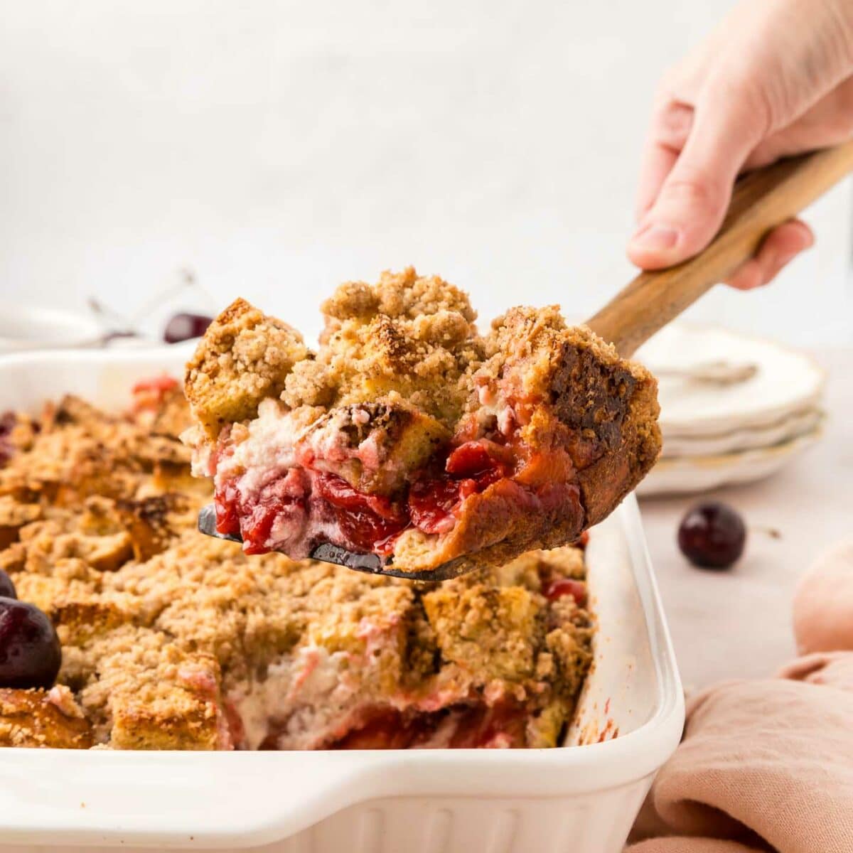 a spoonful of casserole being lifted out of white baking dish