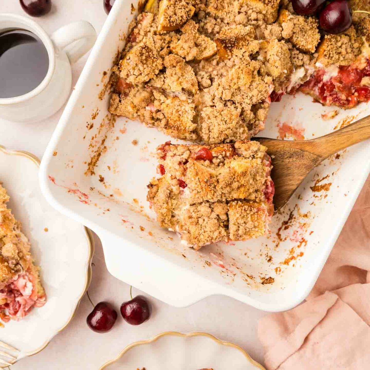 french toast in a white dish with a piece on a wooden spoon