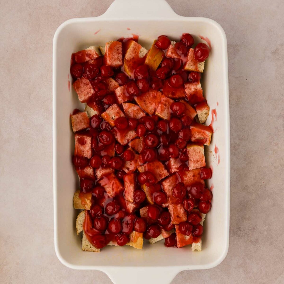 cherry pie filling spread over bread cubes