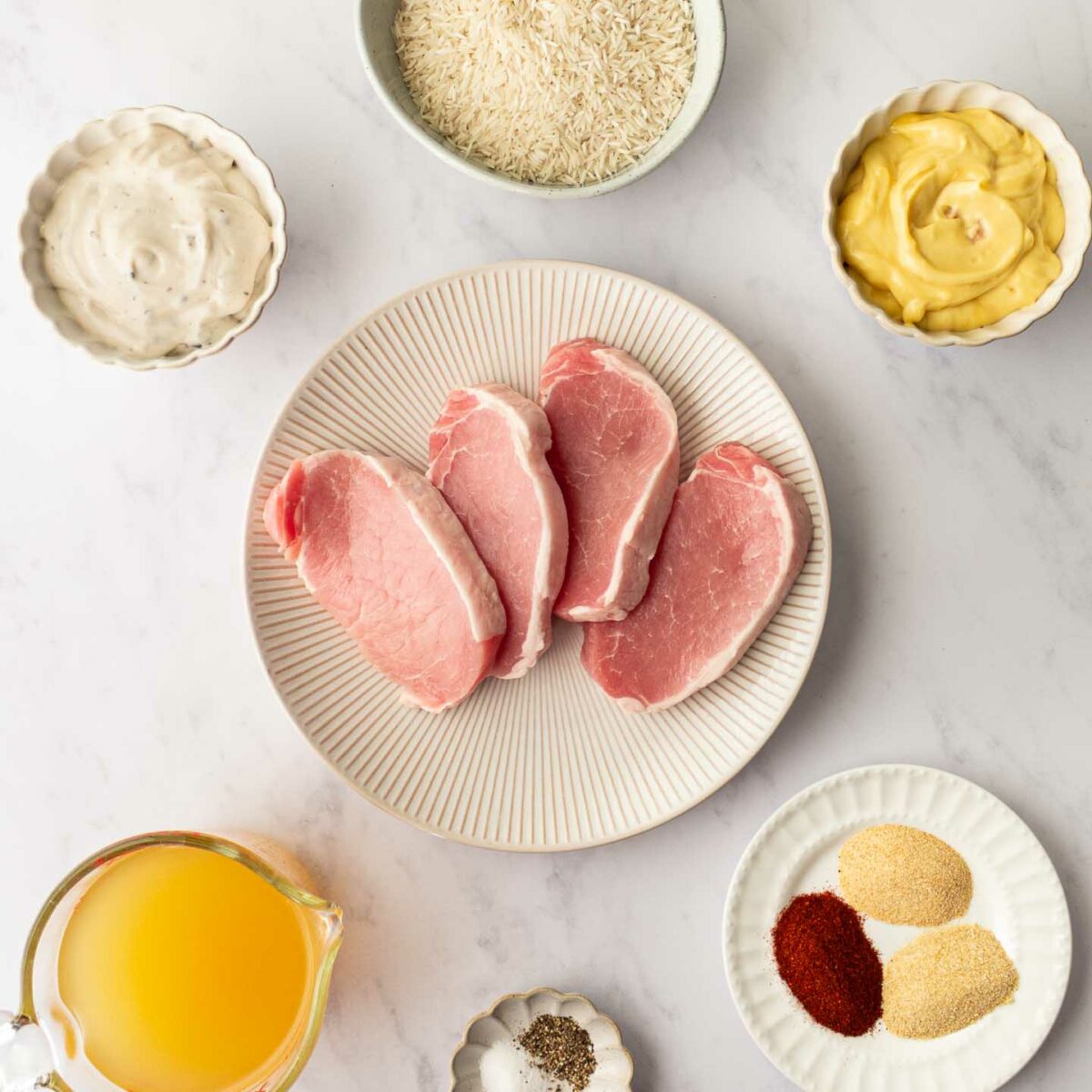 ingredients for pork chops and rice in small dishes